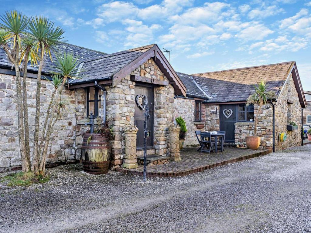 a stone house with palm trees in front of it at 3 Bed in Swansea oc-93942 in Ilston