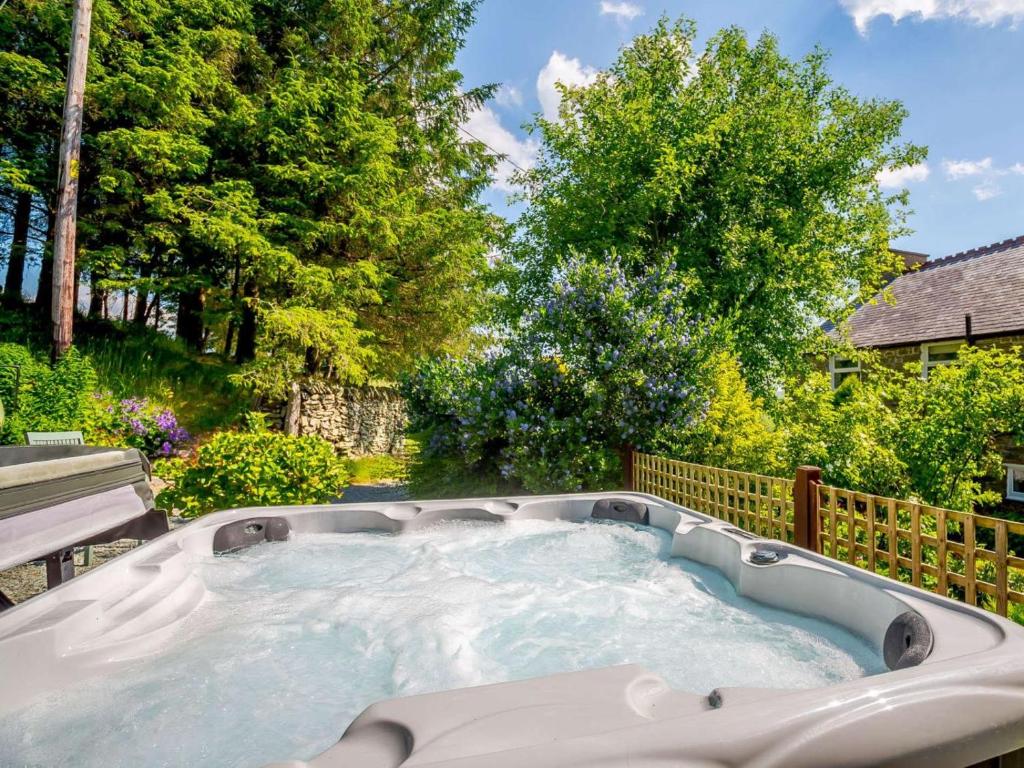 a hot tub in a backyard with trees at 1 Bed in Corwen oc-52509 in Corwen