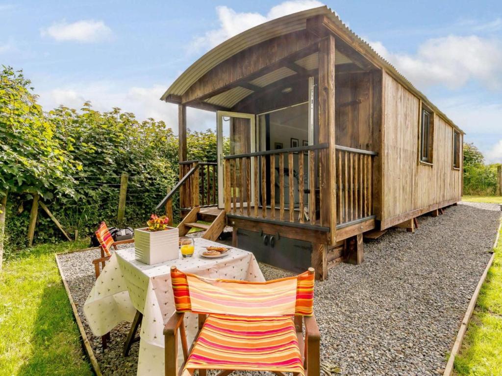 a small wooden cabin with a table and chairs at 1 Bed in Kilgetty oc-88421 in Jeffreston