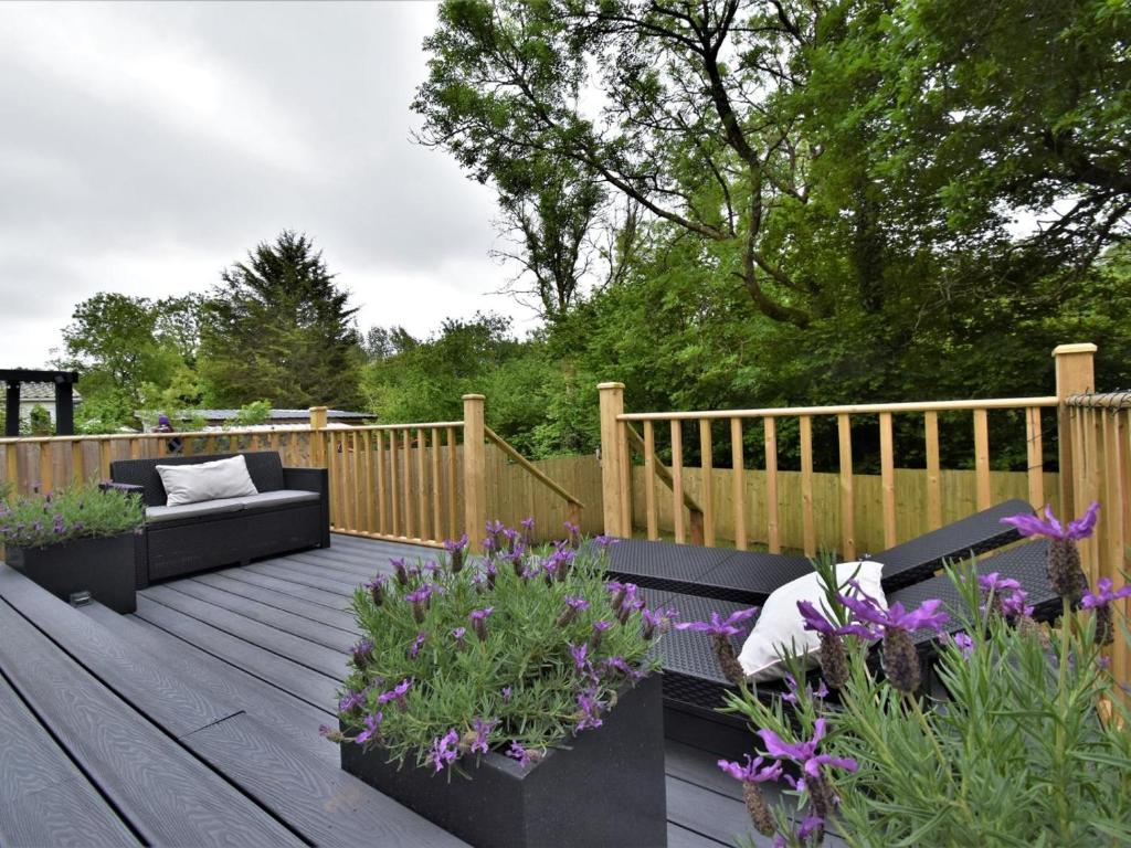 a wooden deck with a couch and some flowers at 3 Bed in Stepaside oc-fb047 in Stepaside