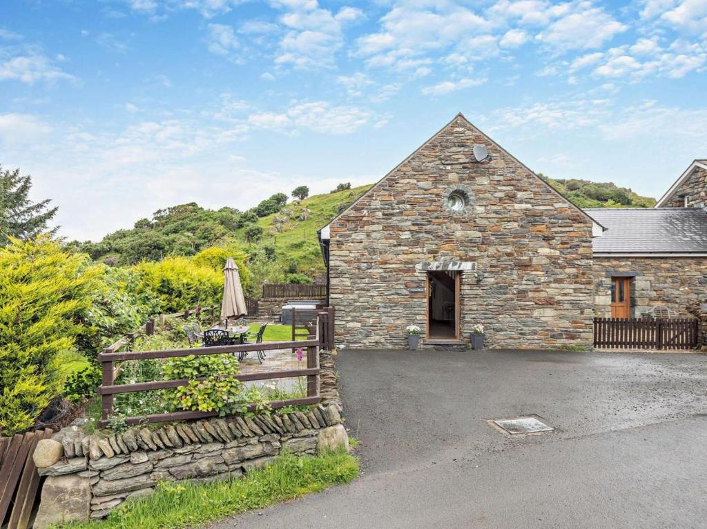a stone barn with a wooden fence and a yard at 3 Bed in Arthog oc-77304 in Arthog