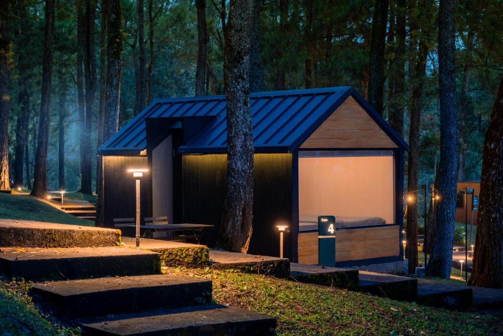 a cabin in the middle of a forest at night at Bobocabin Coban Rondo, Malang in Songgoriti