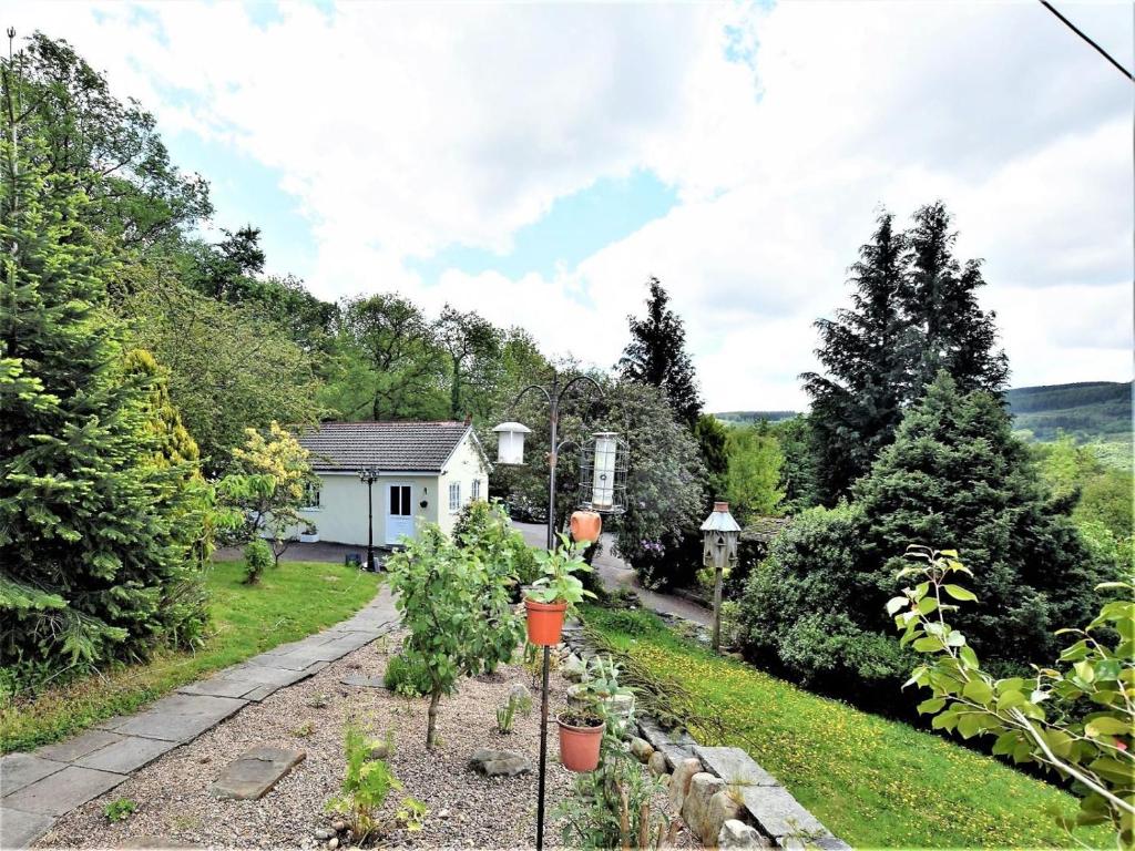 a garden with trees and a white house at 1 Bed in Aberdare oc-82906 in Merthyr Tydfil