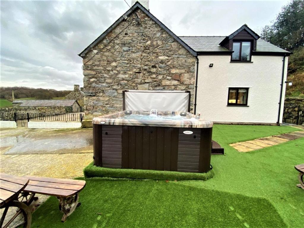 a hot tub in a yard next to a house at 4 Bed in Llanrwst oc-66510 in Llanrwst
