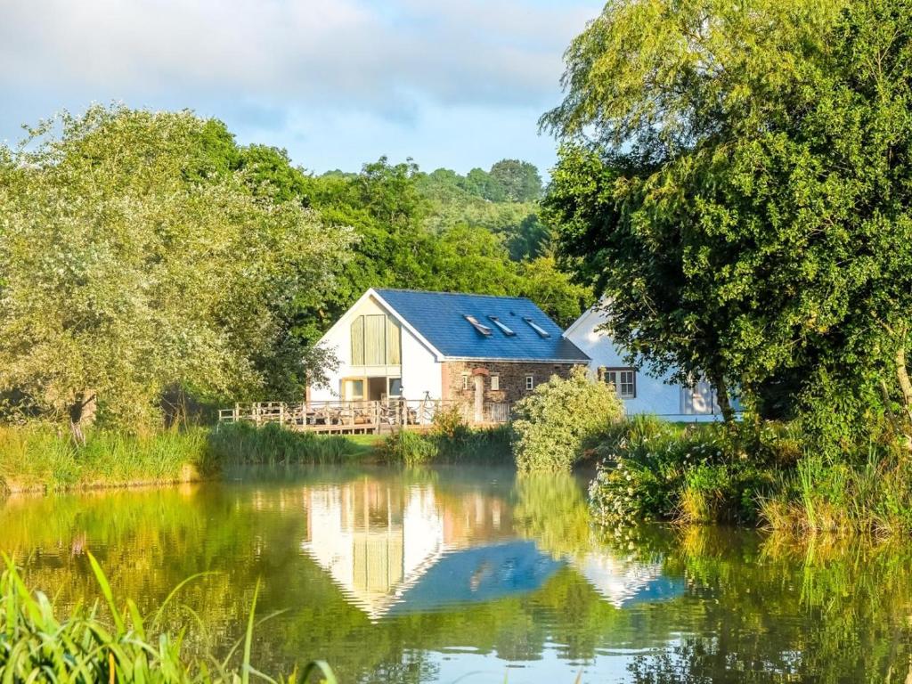 a house next to a river with trees at 2 Bed in Narberth oc-36797 in Llawhaden