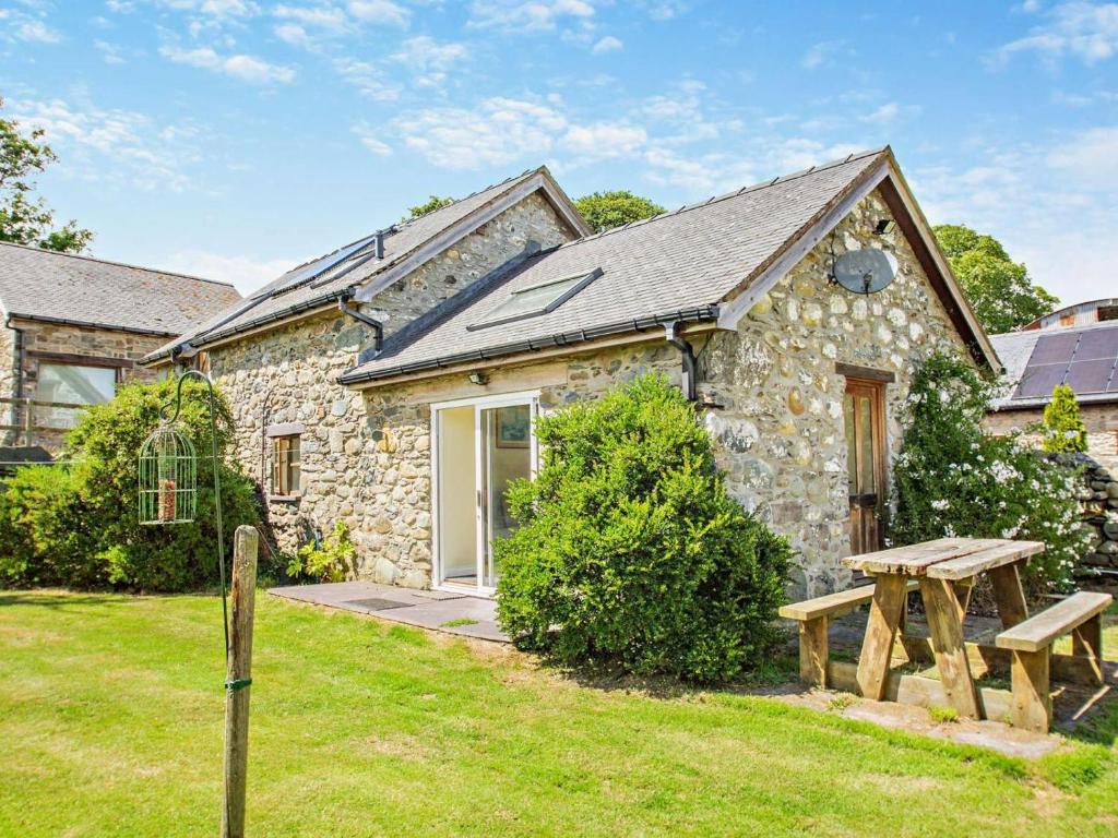 a stone house with a picnic table in front of it at 2 Bed in Conwy oc-42573 in Llangelynin