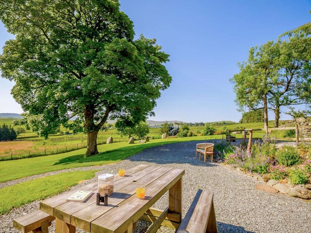 a wooden picnic table with two orange glasses on it at 1 Bed in Corwen oc-52510 in Corwen
