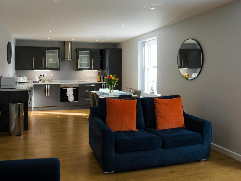 a living room with a blue couch and a kitchen at 2 Bed in Tenby oc-fb284 in Tenby
