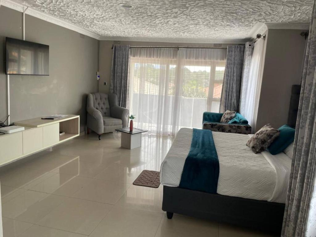a bedroom with a bed and a chair and a window at Alamaison in Umtali