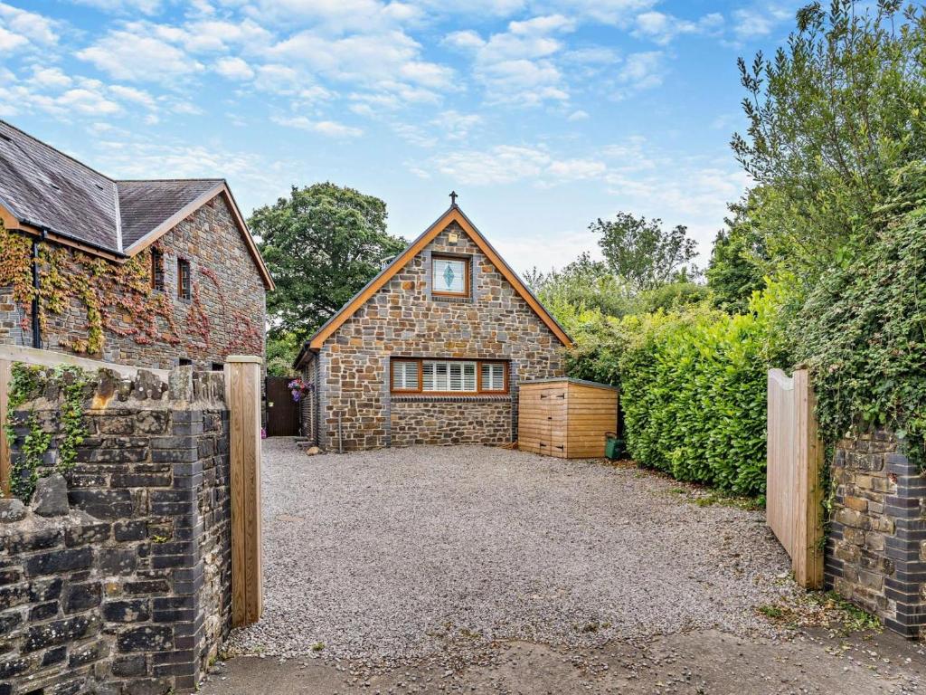 a stone house with a garage and a fence at 2 Bed in Swansea oc-95129 in Penclawdd