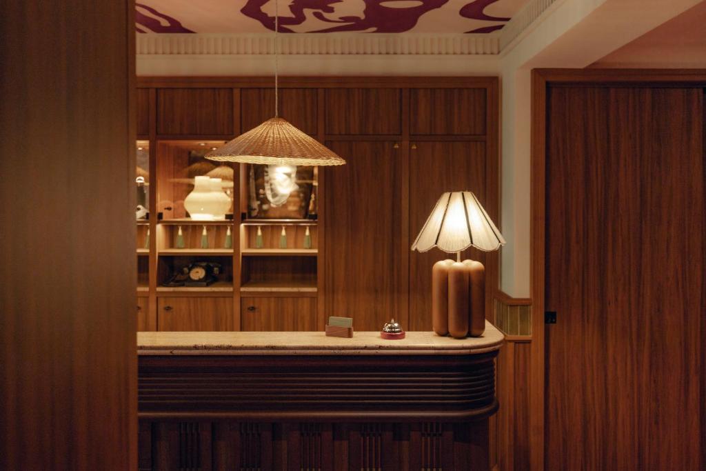 a room with a table with a lamp on it at Salvia Paris in Paris