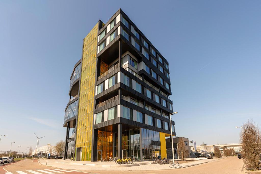 a tall black building with glass windows at Makerstoren Short stay serviced apartments for 28 to 180 days in Amsterdam