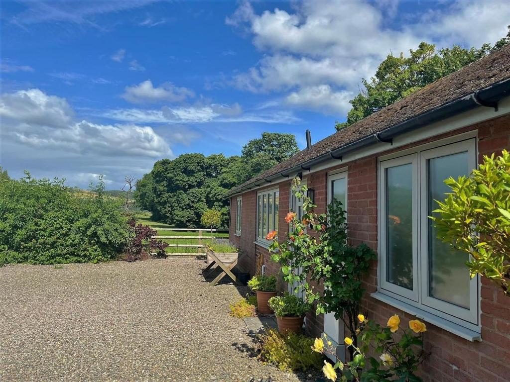 a brick house with a bench and some flowers at 1 Bed in Presteigne oc-78351 in Kinsham