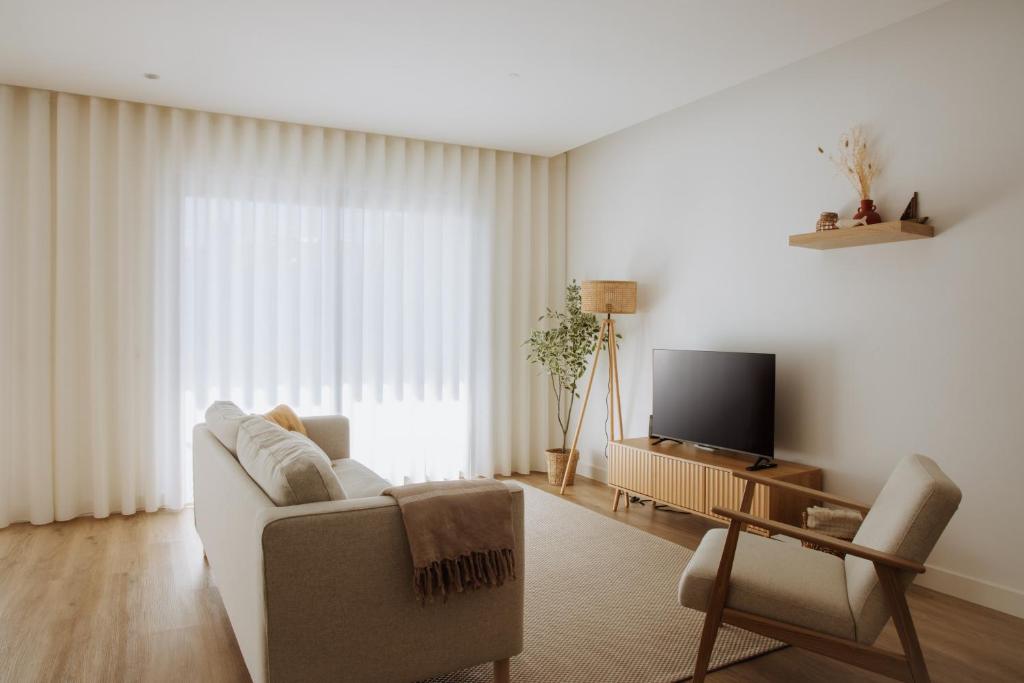 a living room with a couch and a tv at Casa D'Almo in Almograve