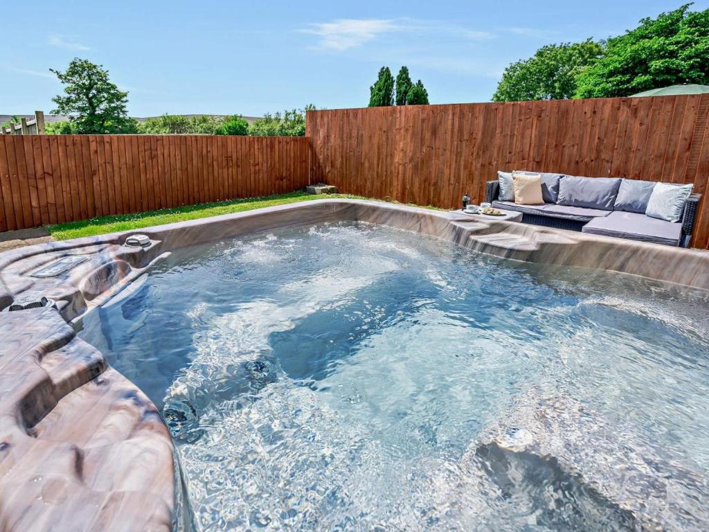a hot tub in a backyard with a fence at 1 Bed in Swansea oc-52906 in Llanrhidian