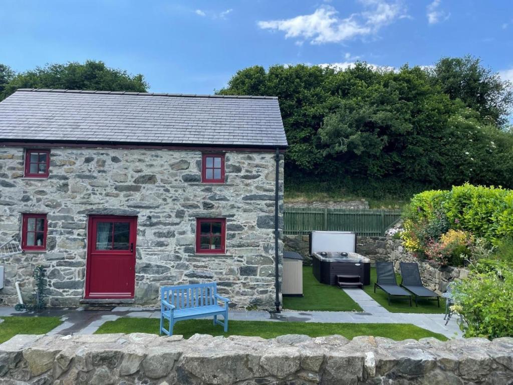a stone house with a red door and a yard at 1 Bed in Llanrwst oc-83950 in Llanrwst