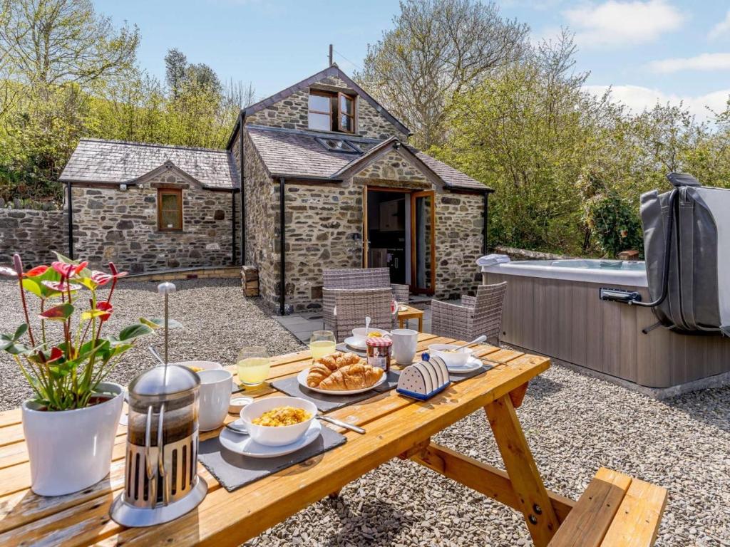 a picnic table with food on it in front of a cottage at 2 Bed in Aberaeron oc-45333 in Aberaeron