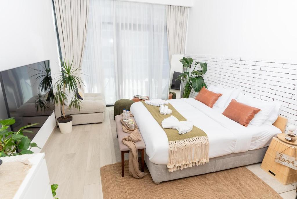 a bedroom with a large bed in a room with plants at Luxurious Studio Hidden Condo In Dubai in Dubai