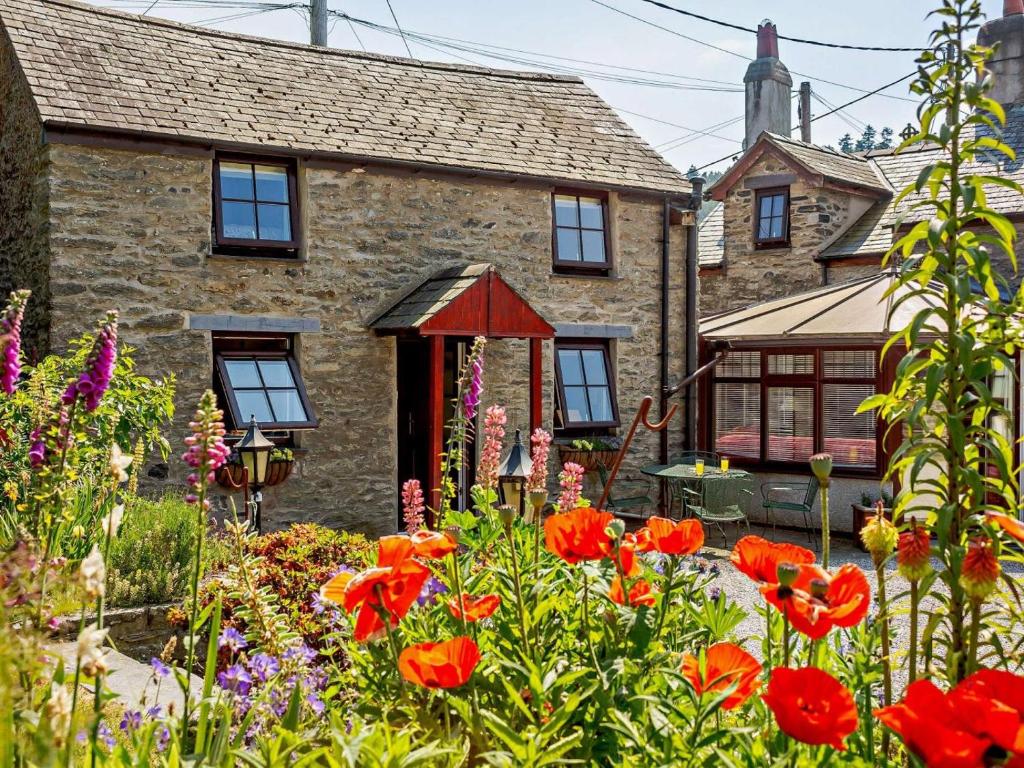 a stone house with flowers in front of it at 2 Bed in Colwyn Bay oc-50933 in Eglwys-Fâch