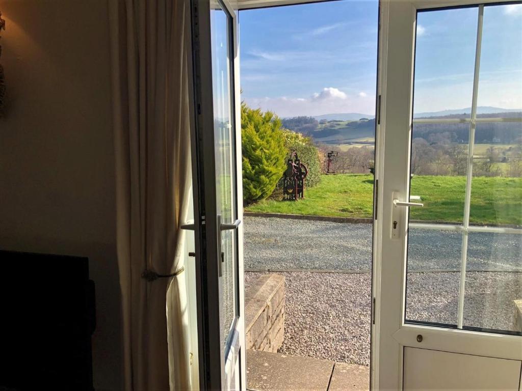 an open door looking out at a view of a field at 3 Bed in Conwy oc-tygos in Llangelynin