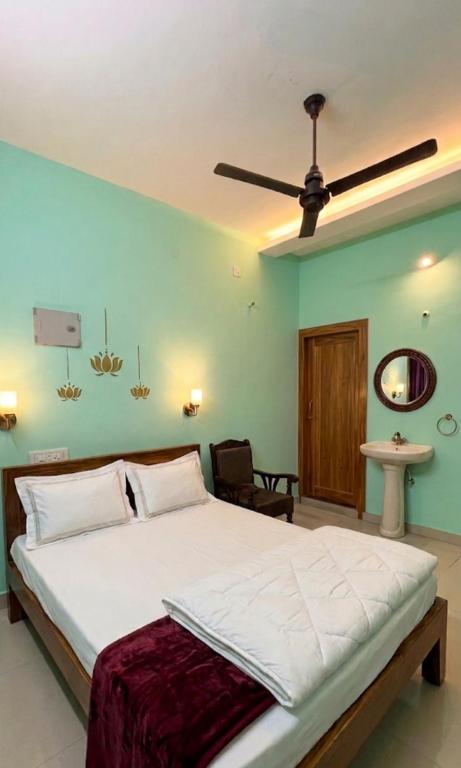 a bedroom with a large bed with a ceiling fan at STAR Residency - G in Pondicherry