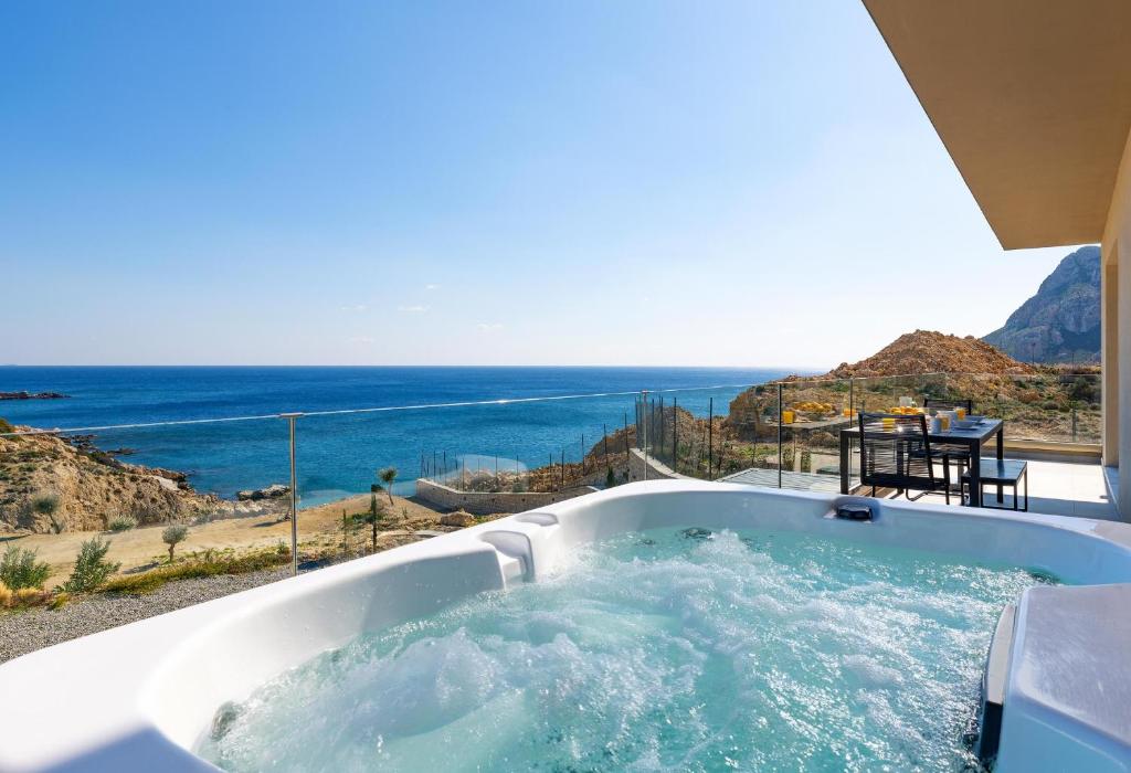 a bath tub with a view of the ocean at Aquamarine Luxury Suites - Stegna - Beachfront, Jacuzzi , Smart Home, Great View in Archangelos