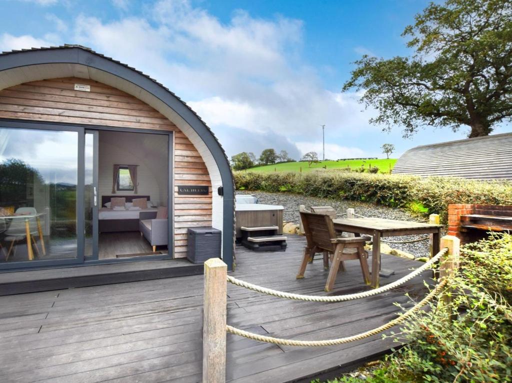 a wooden deck with a table and a dining room at 1 Bed in Corwen oc-80320 in Gwyddelwern