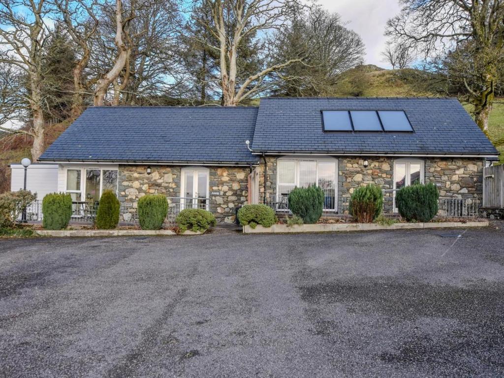 a stone house with a solar roof on a driveway at 2 Bed in Bala oc-86964 in Llandderfel