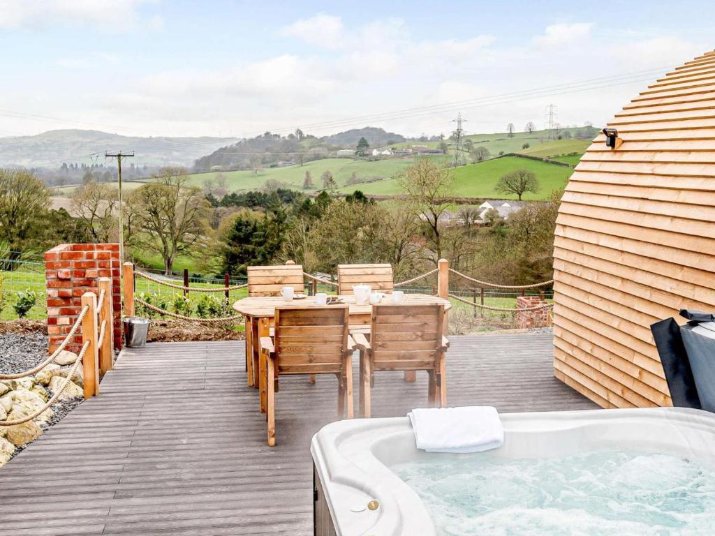 a wooden deck with a table and a bath tub at 1 Bed in Corwen oc-80321 in Gwyddelwern