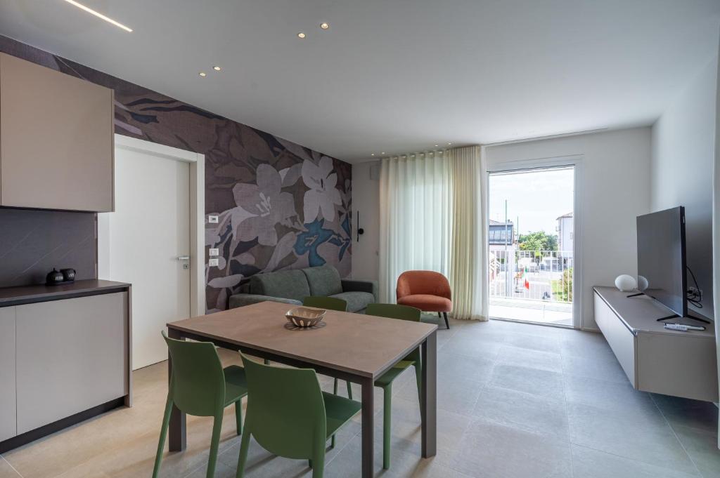 a kitchen and living room with a table and chairs at A&G green flat il mare e Venezia in Cavallino-Treporti