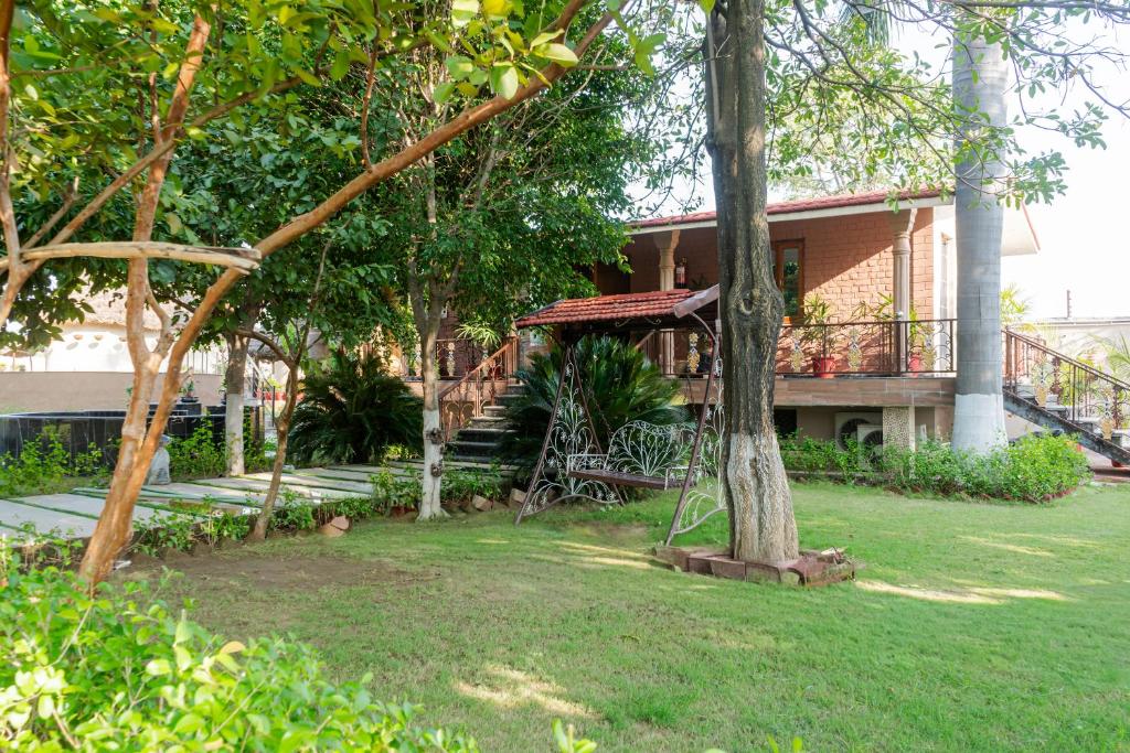 a house with a balcony and a yard with trees at Forest Mud Villas in Haridwār