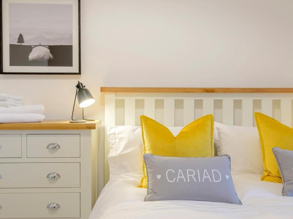 a bedroom with a bed with yellow and white pillows at 2 Bed in Amlwch oc-77640 in Llanfechell
