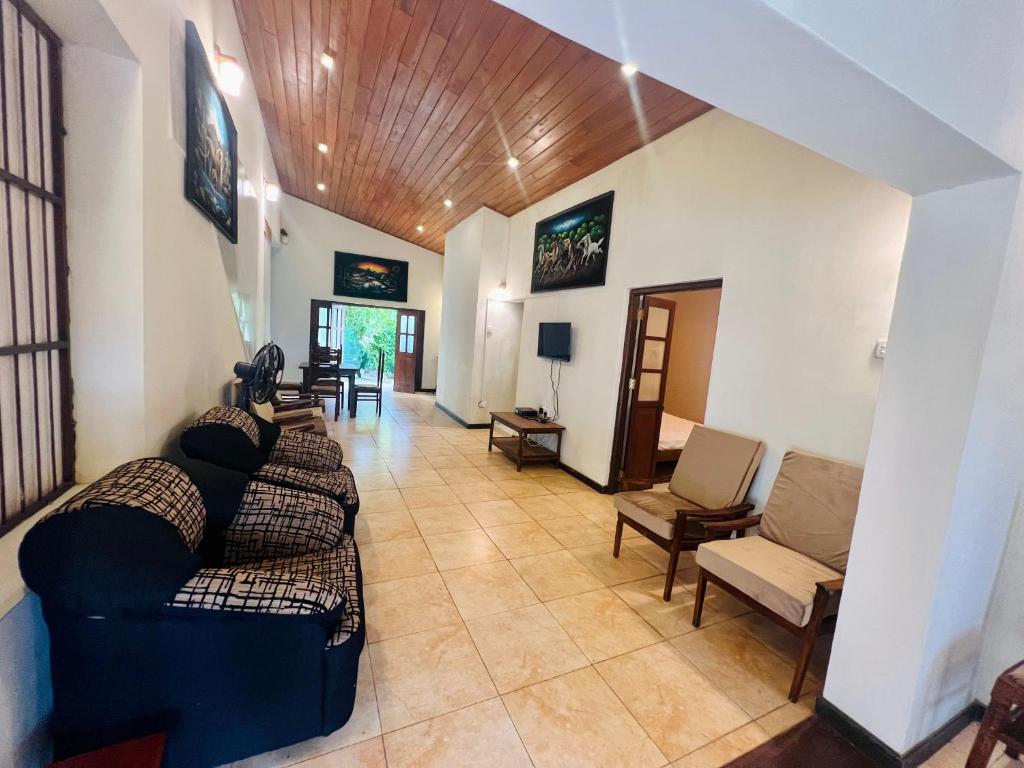 a living room with couches and chairs in a room at Lovely Home in Panadura