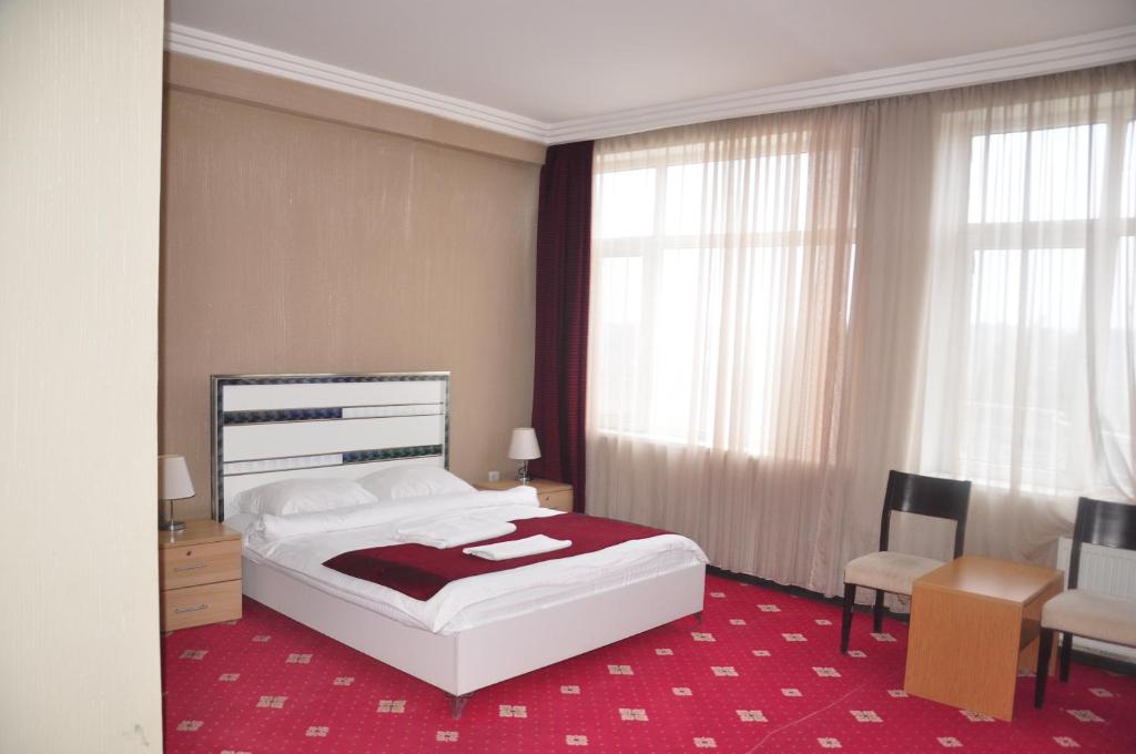 a bedroom with a bed and a desk and a chair at Arena Hotel Tovuz in Tovuz