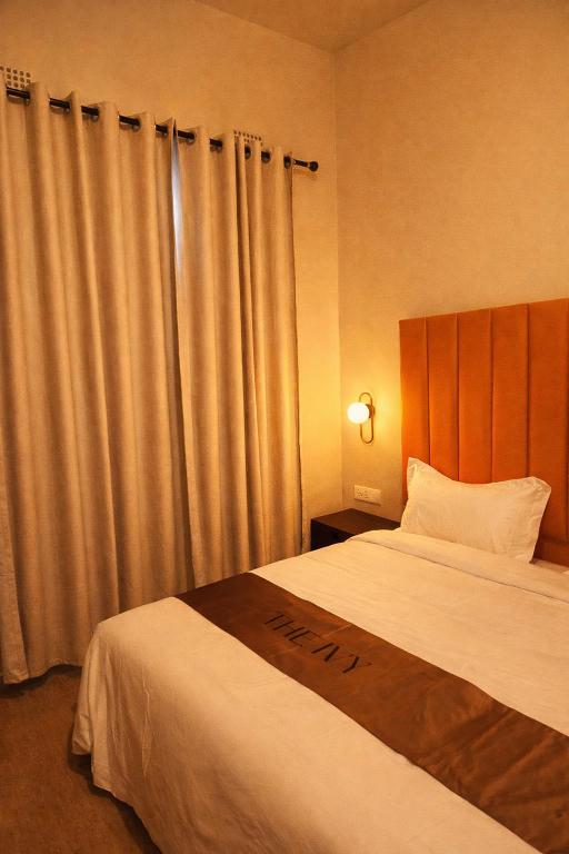 a hotel room with a bed and curtains at The Ivy Hotel in Lusaka