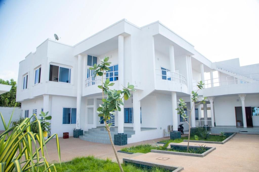 a white building with trees in front of it at Résidences Amana in Porto-Novo