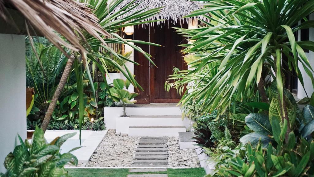 a garden with palm trees and stairs in front of a building at Cala Tuason Villas in General Luna