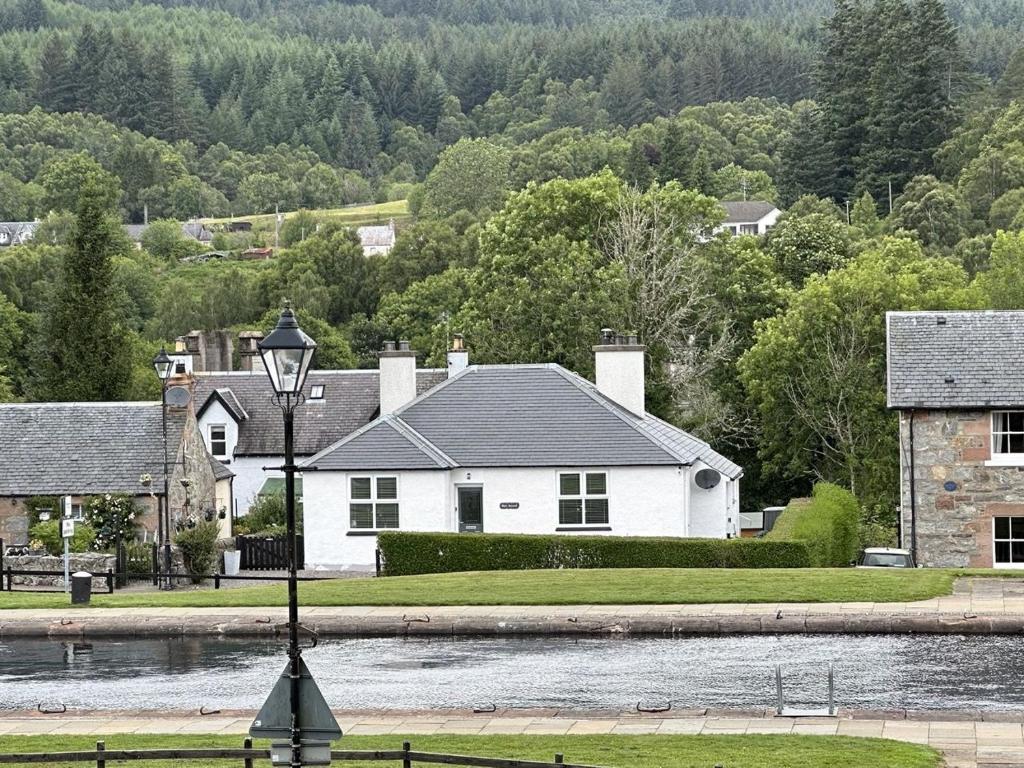 a house with a street light in front of a river at Bon Accord in Fort Augustus