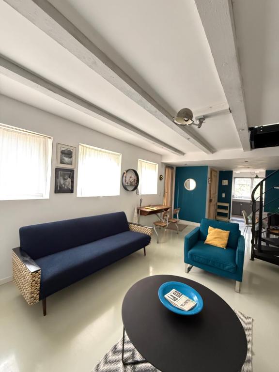 a living room with a blue couch and a table at L'Atelier des dépendances in Lipsheim