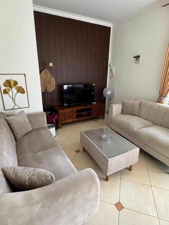a living room with two couches and a flat screen tv at Lamar Villas 2 in Tengahgirang