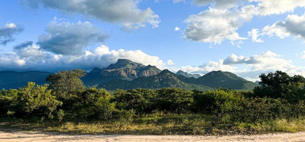 a view of a mountain range with trees and clouds at 24 Degrees South Country Estate in Hoedspruit