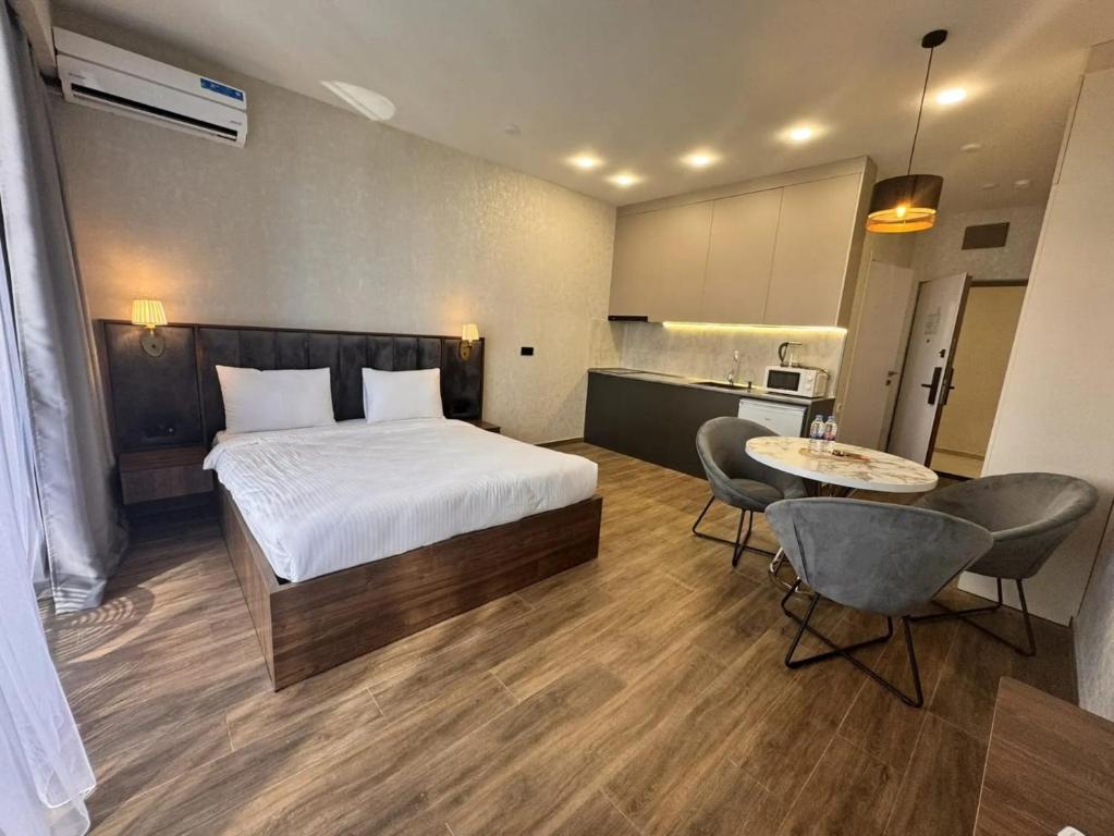 a bedroom with a bed and a table and chairs at Solis apart otel in Batumi