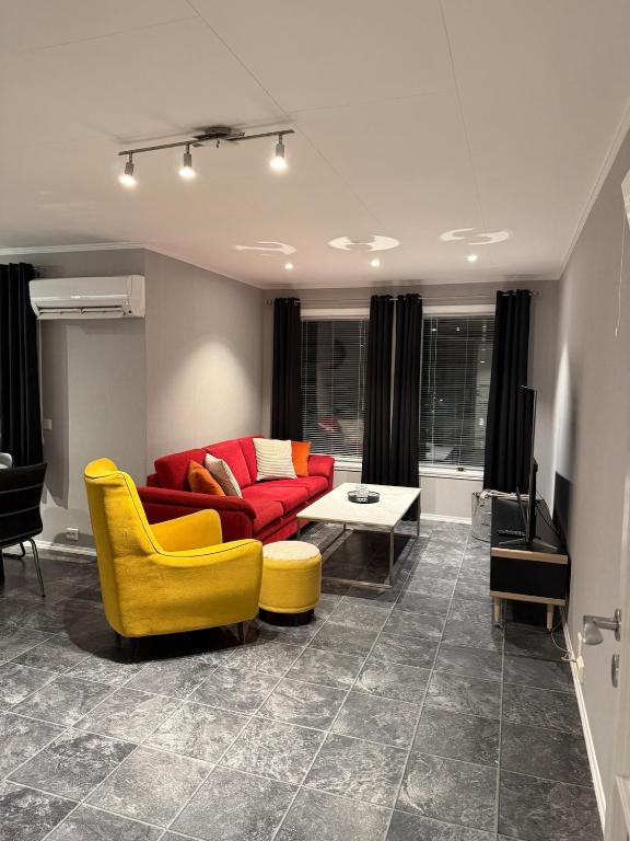 a living room with a red couch and a yellow chair at Sokkelleilighet in Grindheim