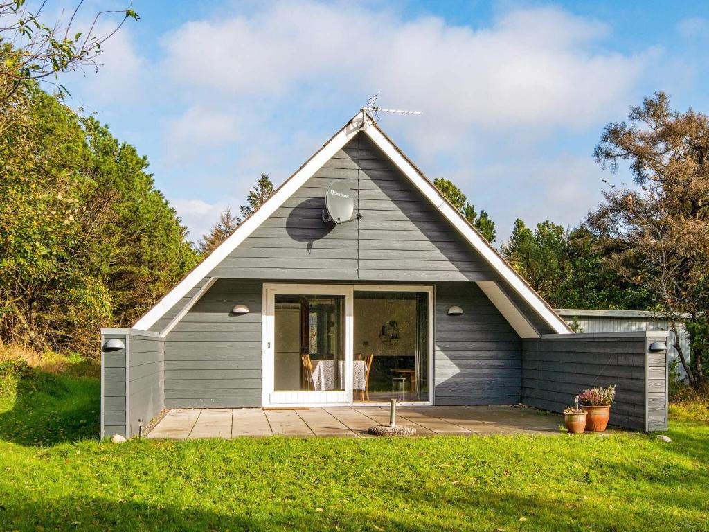 a small gray house with a porch at 6 person holiday home in Ringkøbing in Ringkøbing