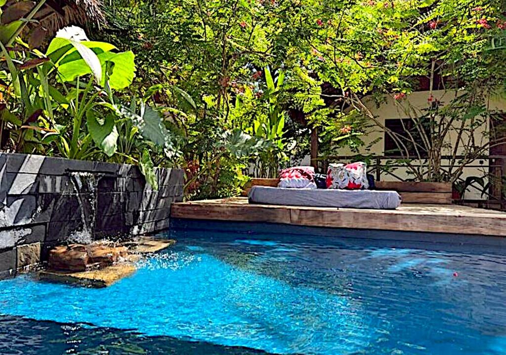a swimming pool with a bed in the middle of it at Bungalow du Lagon in Ambaro
