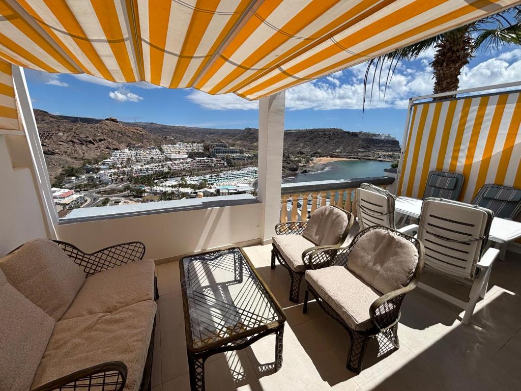 a balcony with chairs and a view of a city at Vista Mar in Mogán