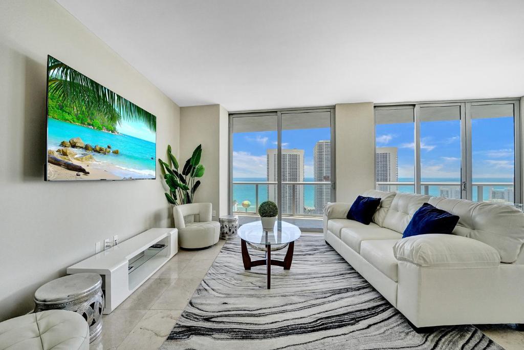 a living room with a white couch and a table at Beachwalk Resort in Hallandale Beach