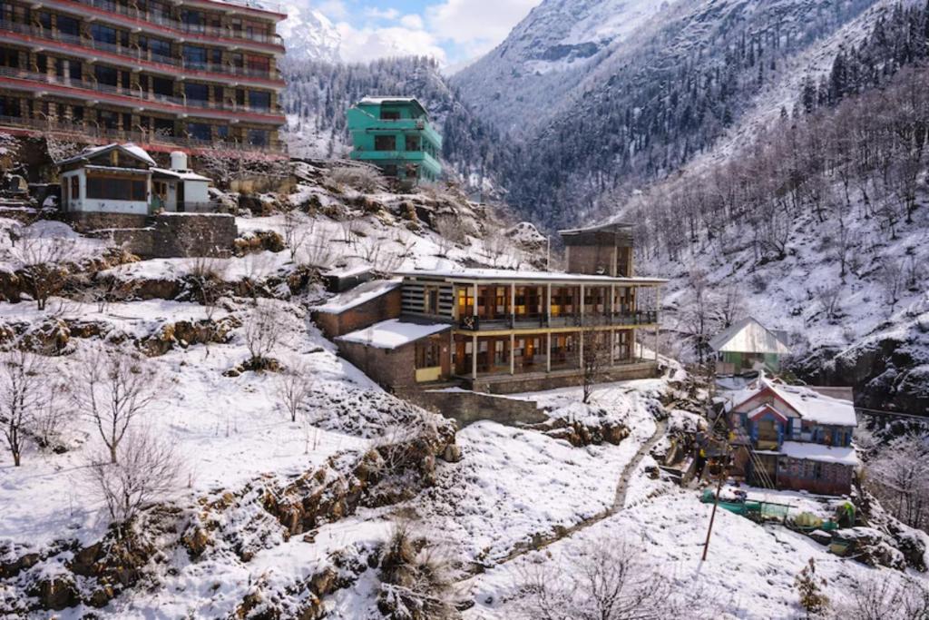 a building on top of a snowy mountain at Yellowjackets Hostel Tosh in Tosh