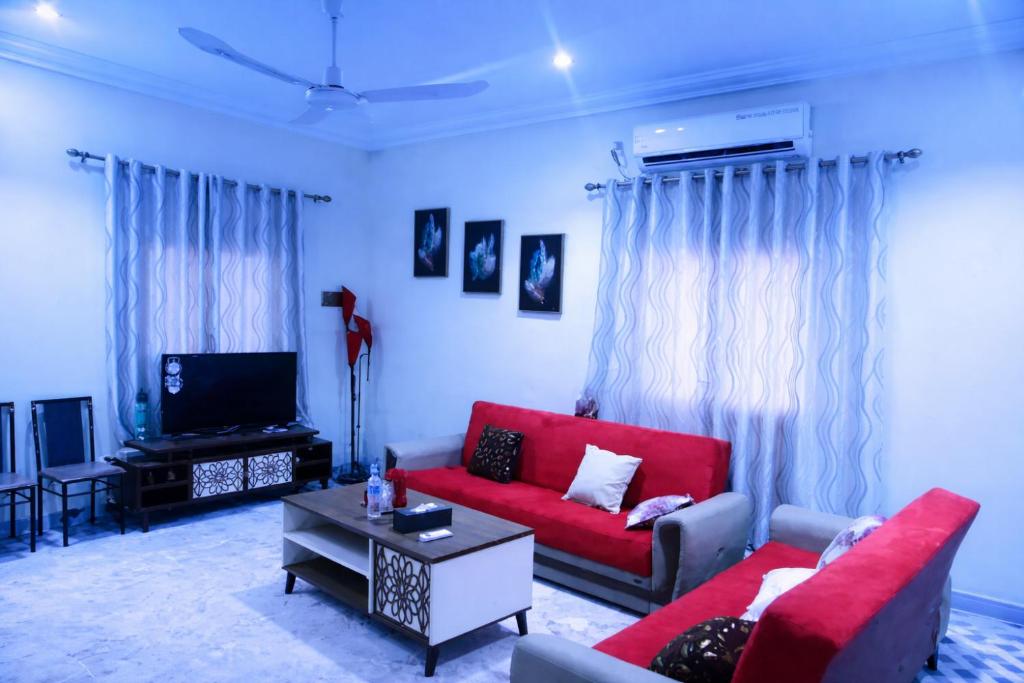 a living room with a red couch and a tv at Villa Sahel in Niamey