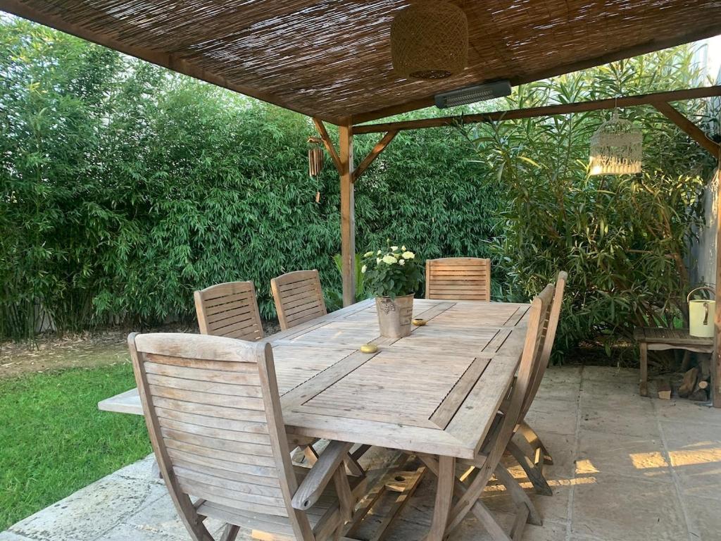 a wooden table and chairs under a wooden umbrella at belle maison 3000 m de Paris in Cachan